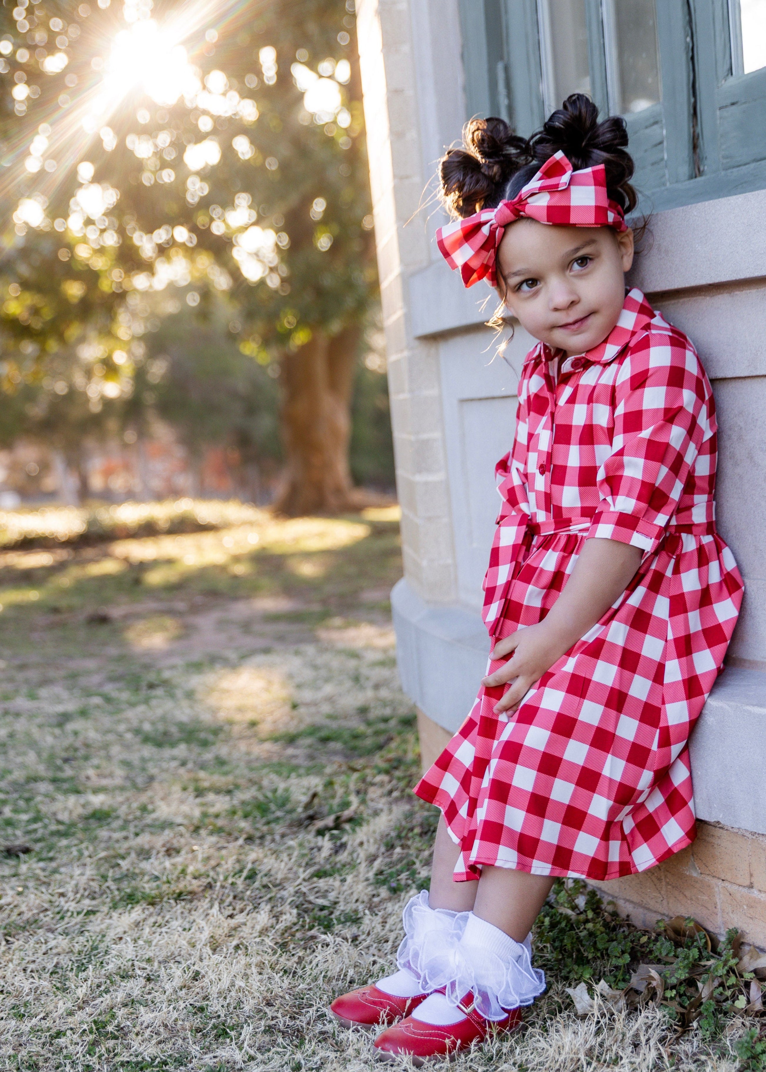 Model wearing the Nuggles® Girls' Rachel Dress and matching Headband in Cherry Jam