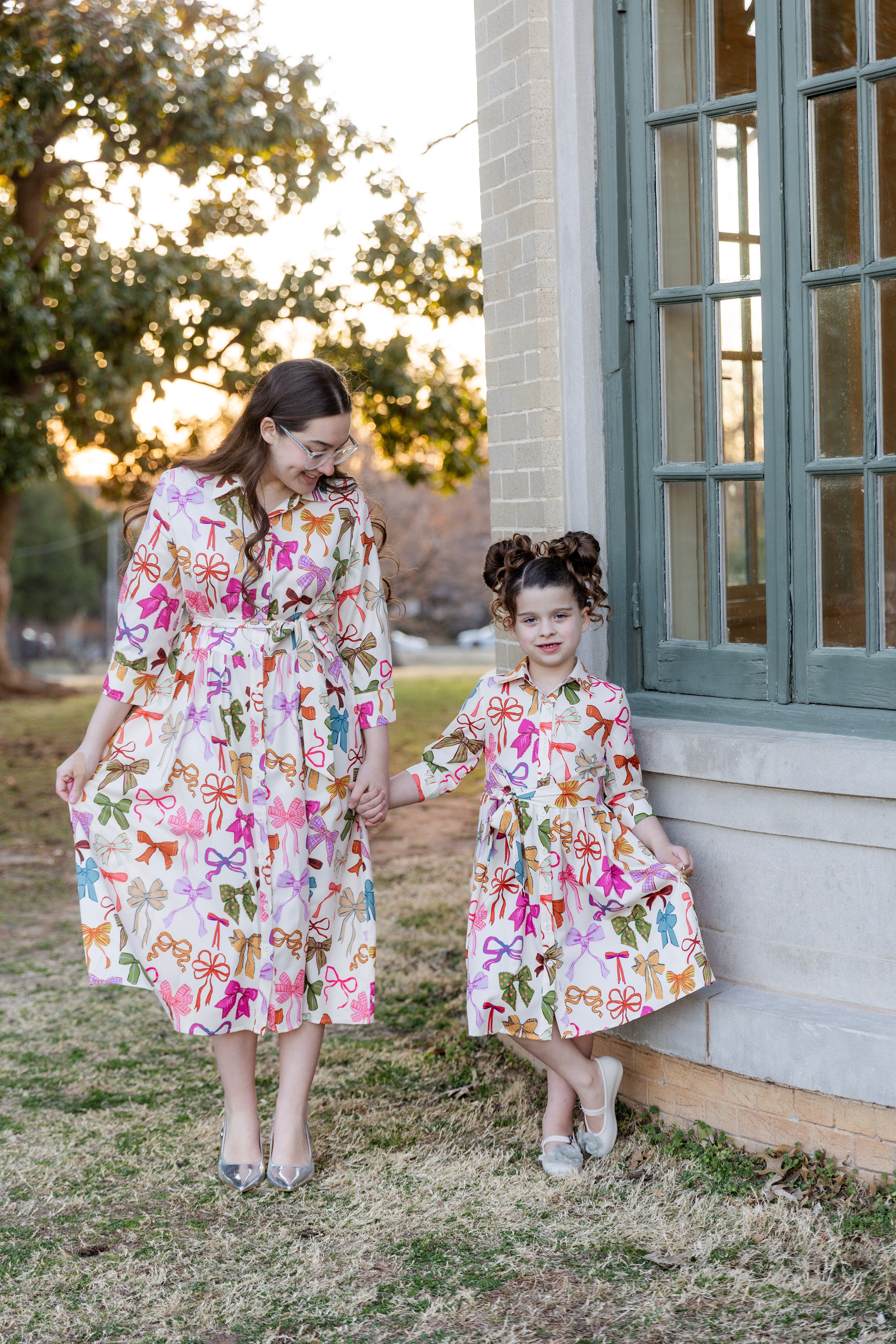 Model wearing the Nuggles® Girls' Rachel Dress in Bow Garden