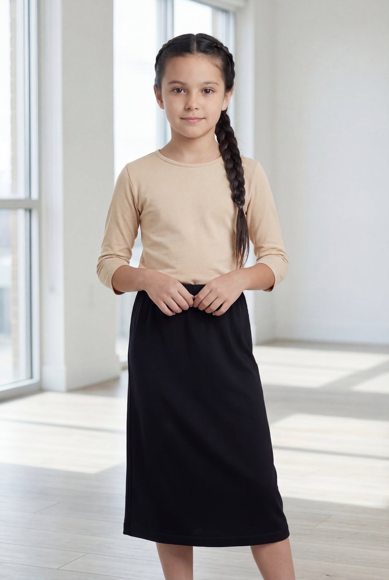 Model wearing the Nuggles® Girls' Classic Midi Skirt in Black