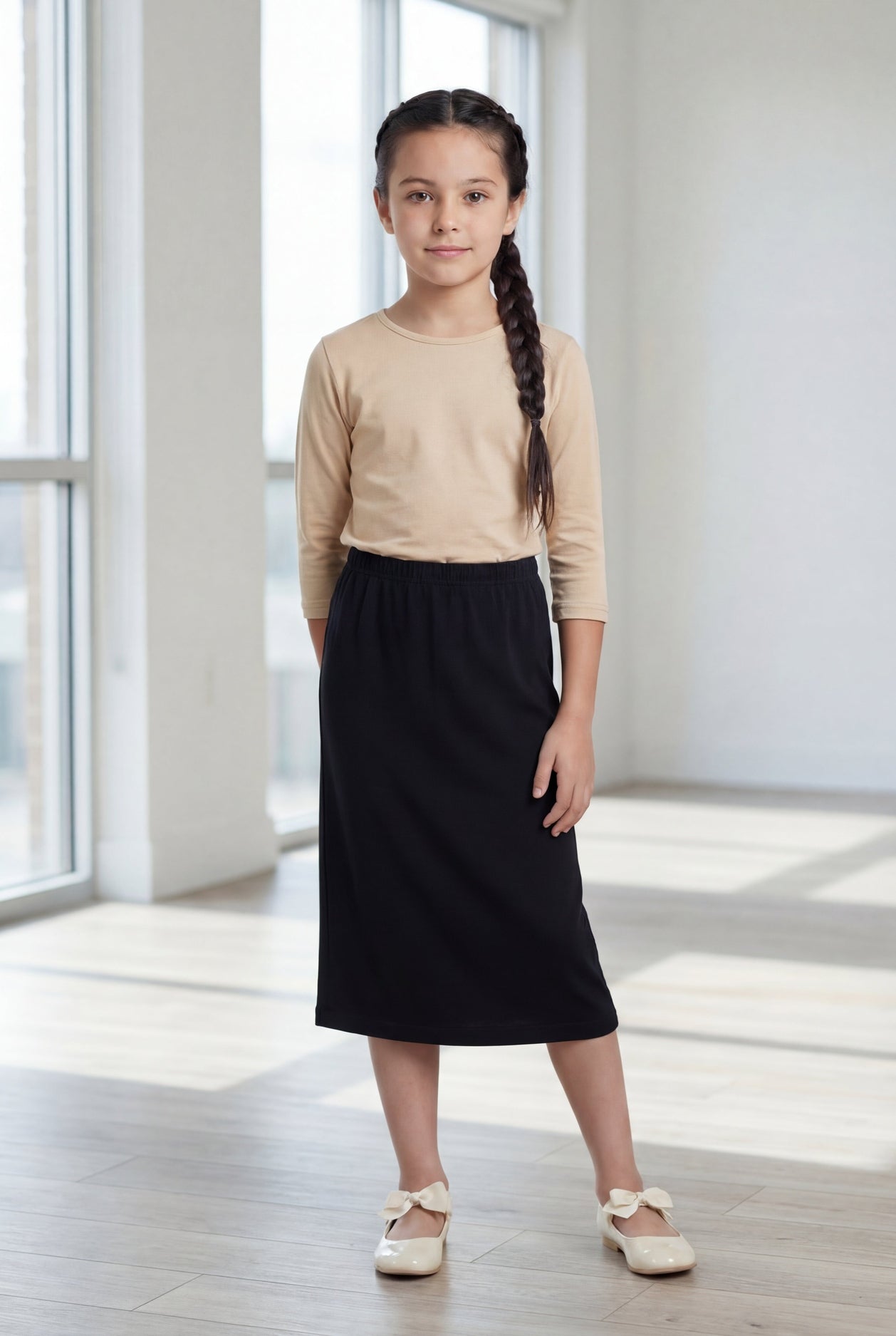 Model wearing the Nuggles® Girls' Classic Midi Skirt in Black