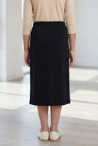 Model wearing the Nuggles® Girls' Classic Midi Skirt in Black