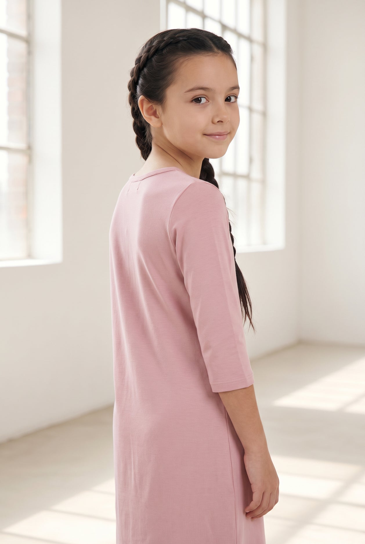 Model wearing Nuggles® Girls Layering Dress in Baby Pink