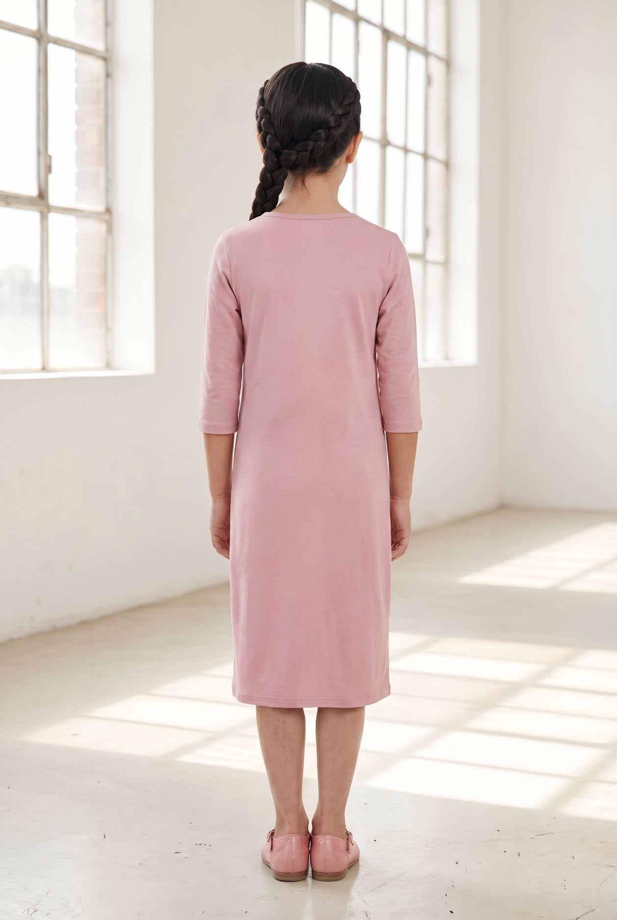 Model wearing Nuggles® Girls Layering Dress in Baby Pink