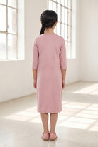 Model wearing Nuggles® Girls Layering Dress in Baby Pink