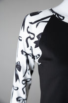 A close up picture of the black and white bow print on a 3/4 sleeve top. 