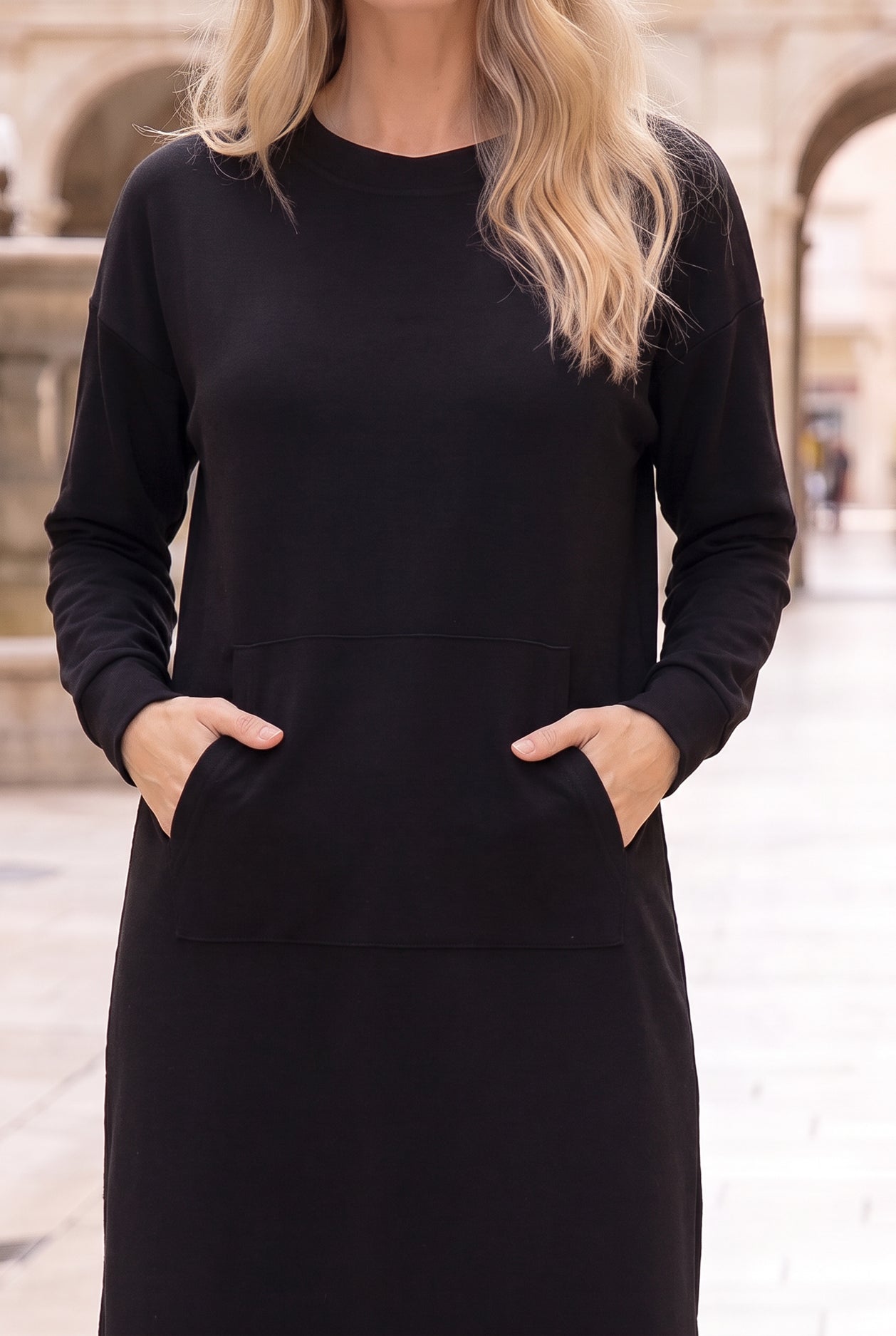 Nuggles® Oakley Hoodie Dress in Black, close-up with both hands tucked in the front pocket