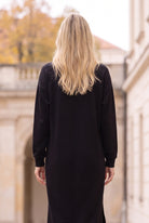Nuggles® Oakley Hoodie Dress in Black, back view with long blonde hair over the shoulders and relaxed long sleeves