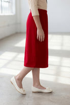 Girl wearing Nuggles® Modest Midi Skirt in Brick Red with a nude essential 3/4 tee in a sun light loft