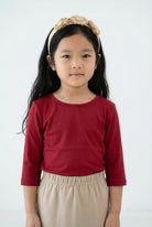 Model wearing the Girls' Nuggles® Essential 3/4 Tee in Brick Red