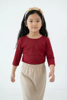 Model wearing the Girls' Nuggles® Essential 3/4 Tee in Brick Red
