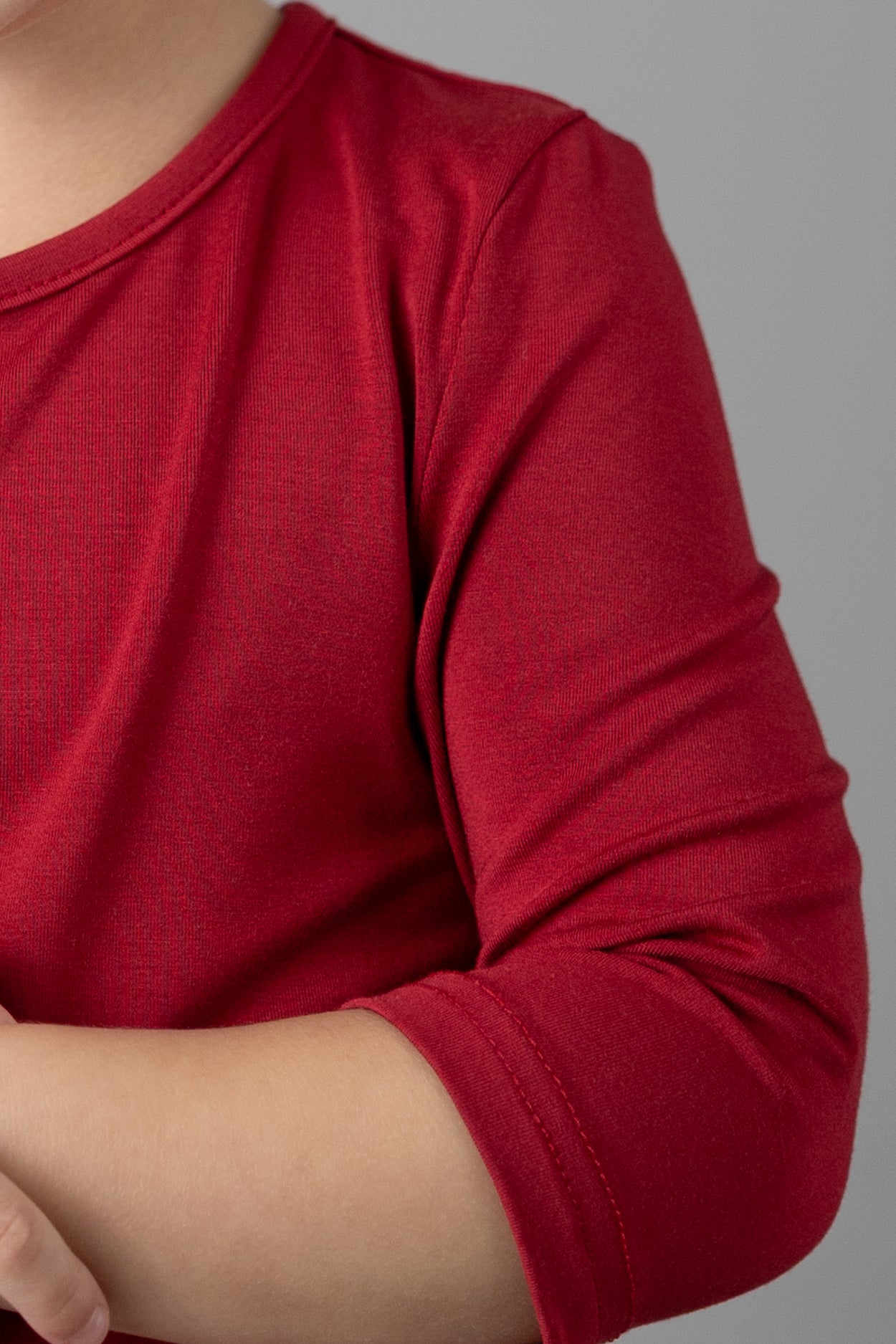 Model wearing the Girls' Nuggles® Essential 3/4 Tee in Brick Red