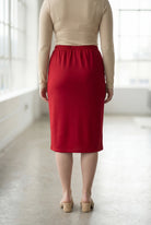 Women wearing a brick red classic 27" midi length skirt with a beige shirt in a sunlight loft.