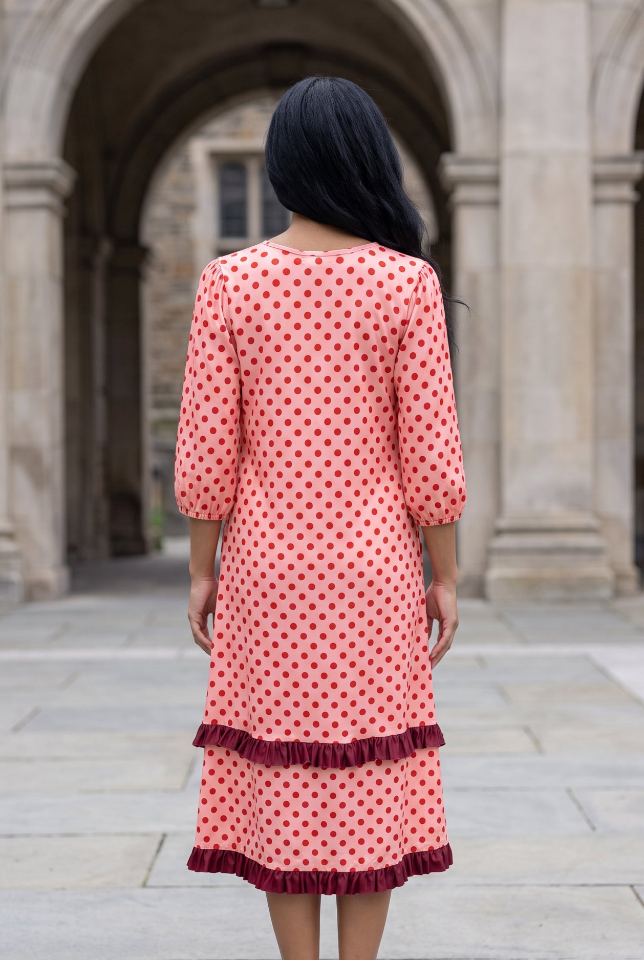 Nuggles® Patricia Dress in Cherry Dot, full-length back view with the burgundy ruffle tiers at the hem