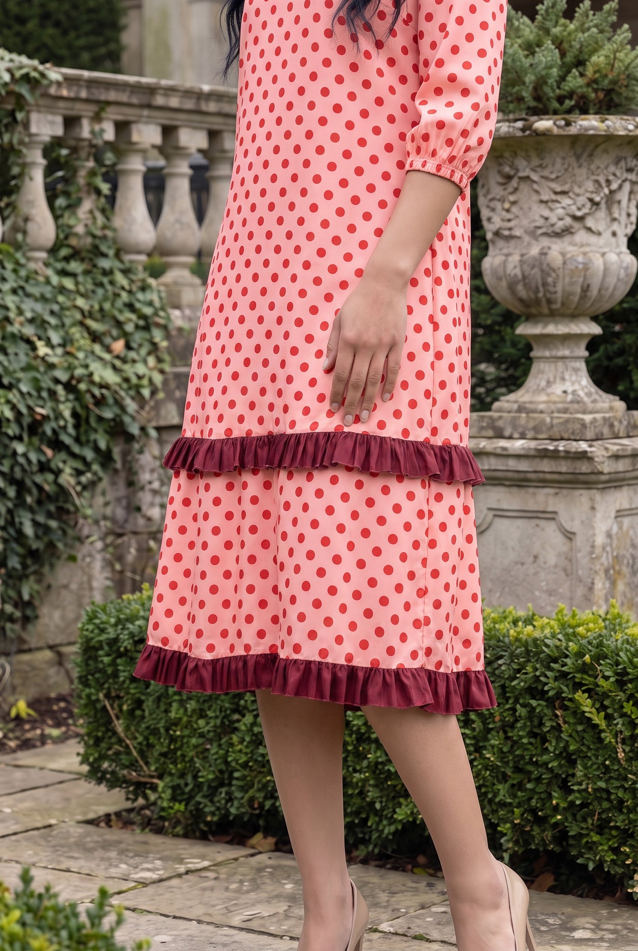 Nuggles® Patricia Dress in Cherry Dot, side crop of the tiered skirt and its two burgundy ruffles