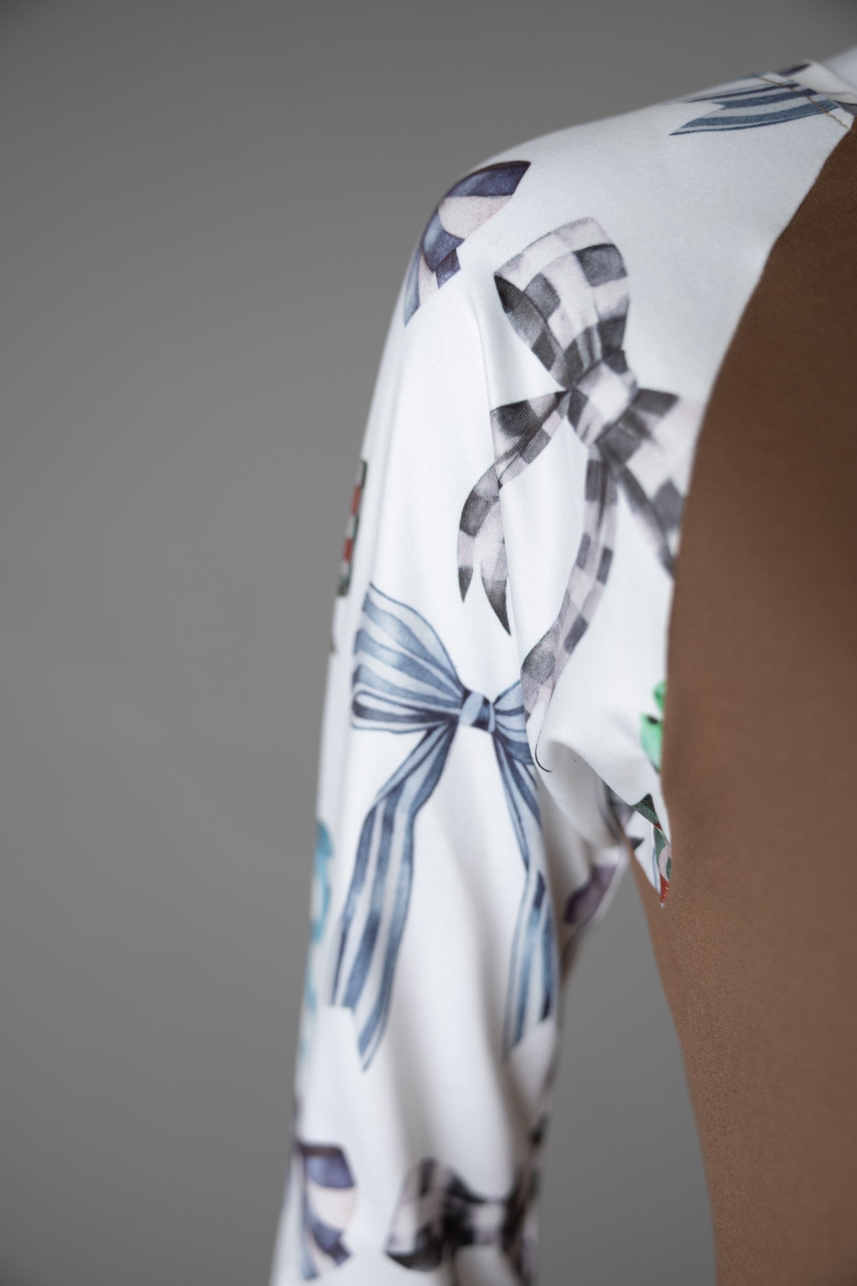 A close up picture of the sleeve of the a brown 3/4 sleeve top. 