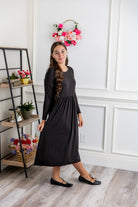 Nuggles® Farah Dress in solid color, modest long sleeve midi dress with empire waist, styled with flats for everyday wear.