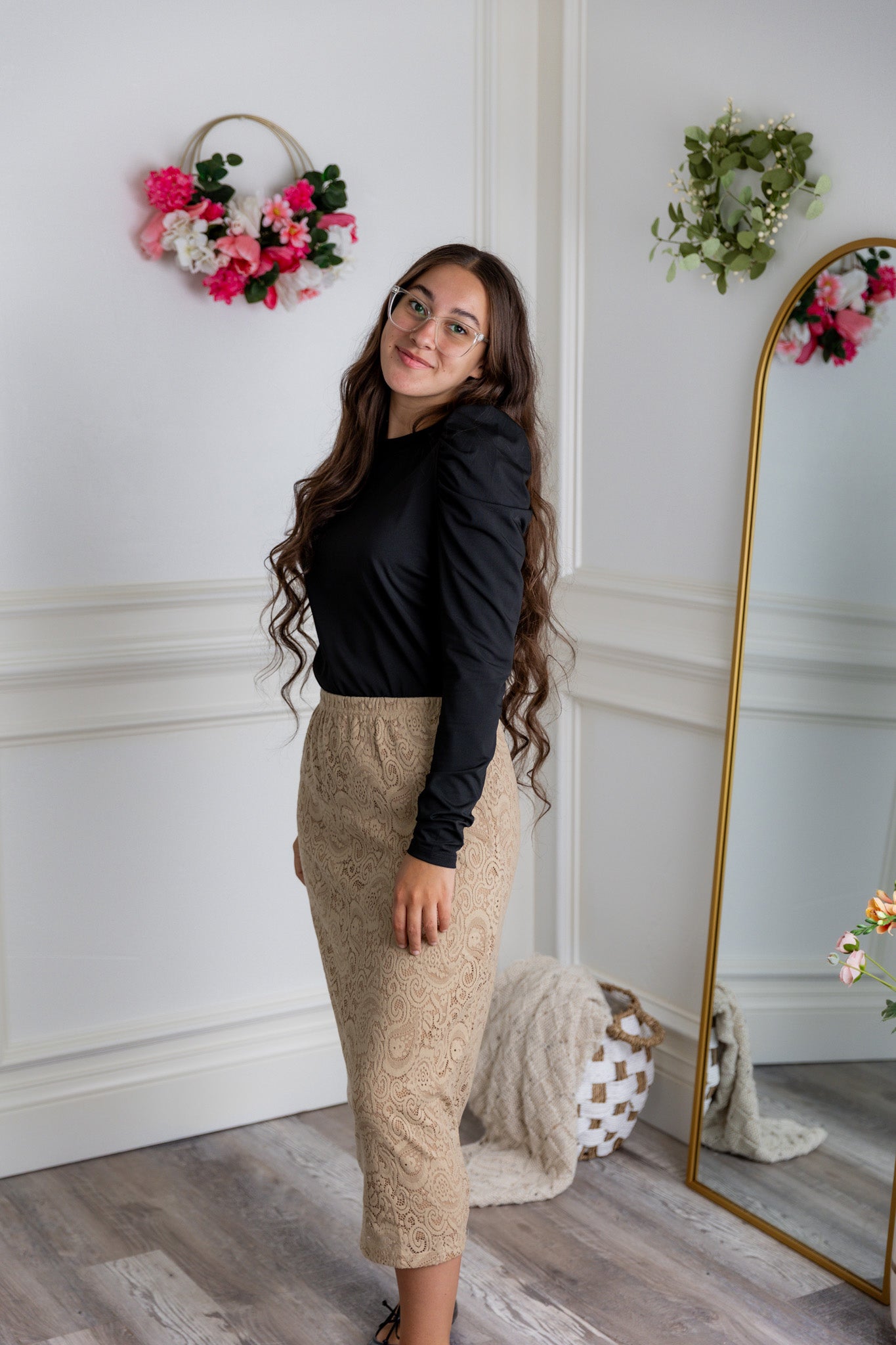 Model wearing the Nuggles® Karina Lined Lace Skirt with modest midi length, paisley lace overlay, and pull-on elastic waistband.