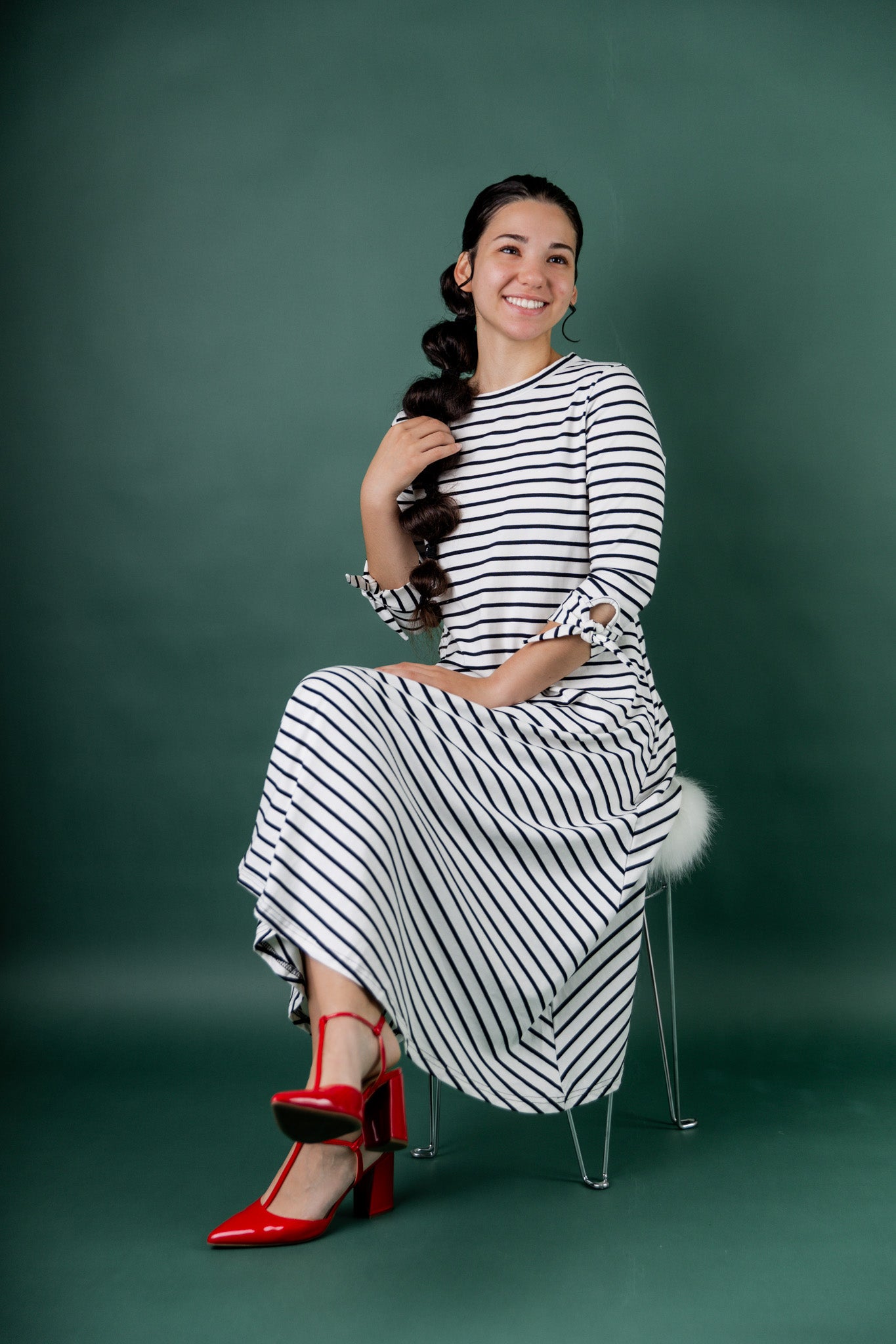 Model wearing the Nuggles® Gracie Dress, a modest A-line midi dress with ¾ sleeves and tie accents, made from soft knit fabric.