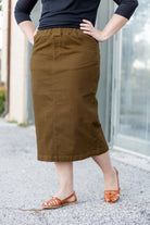 Nuggles® denim midi skirt with soft stretch fabric, wide elastic waistband, modest length, and functional pockets. Available in 27", 31", and 34" lengths.