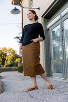 Nuggles® denim midi skirt with soft stretch fabric, wide elastic waistband, modest length, and functional pockets. Available in 27", 31", and 34" lengths.