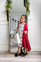 Nuggles® Raegan girls’ dress demonstrated on young model for product listing.