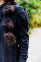 Model wearing Nuggles® Zoelle Dress in solid color, modest hoodie dress with puff sleeves.