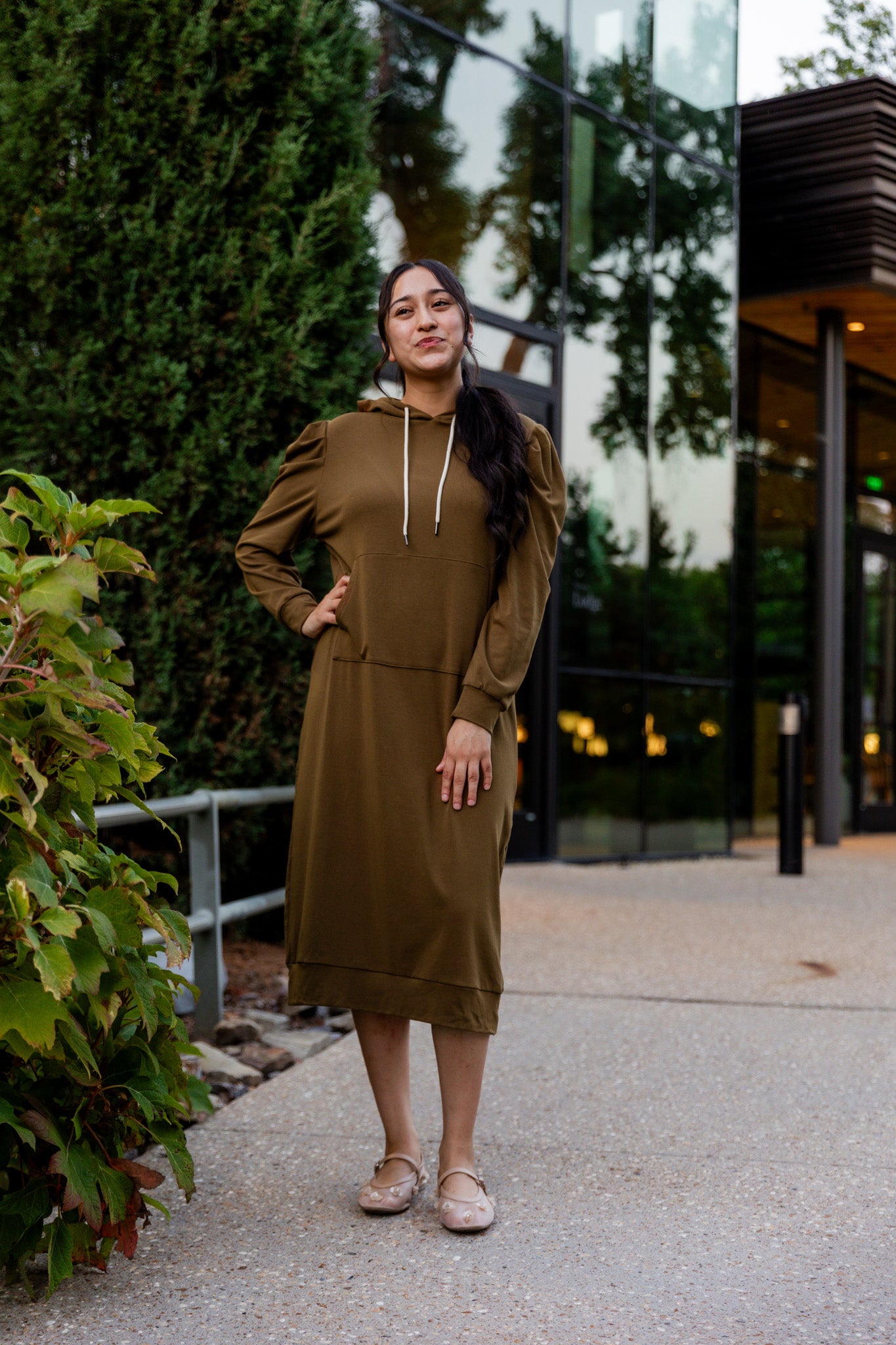 Model wearing Nuggles® Zoelle Dress in solid color, modest hoodie dress with puff sleeves.