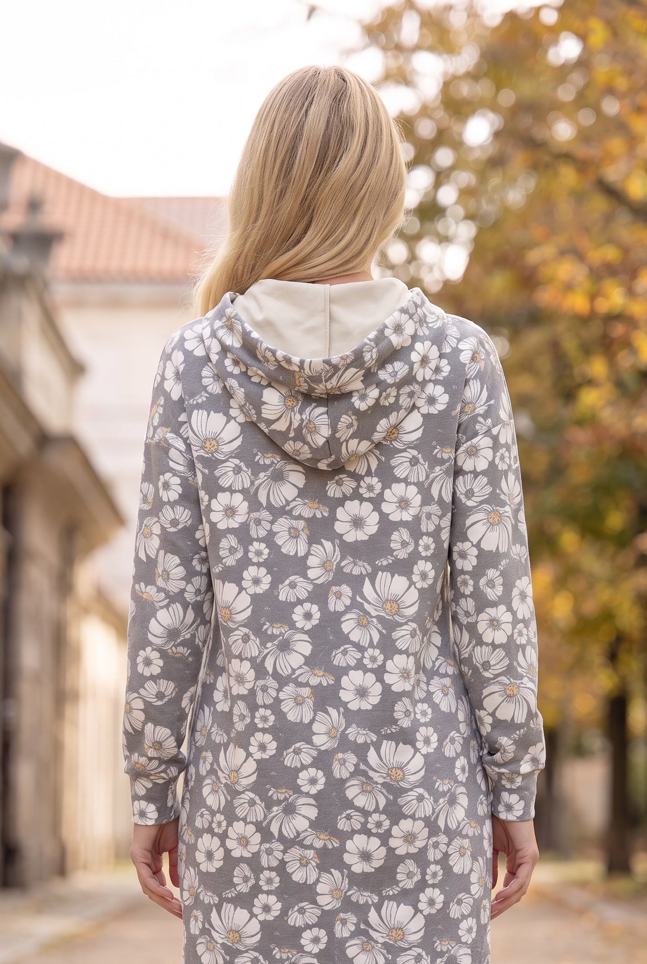 Nuggles® Hoodie Dress in Daisy Moon, back view with the hood down over its cream lining