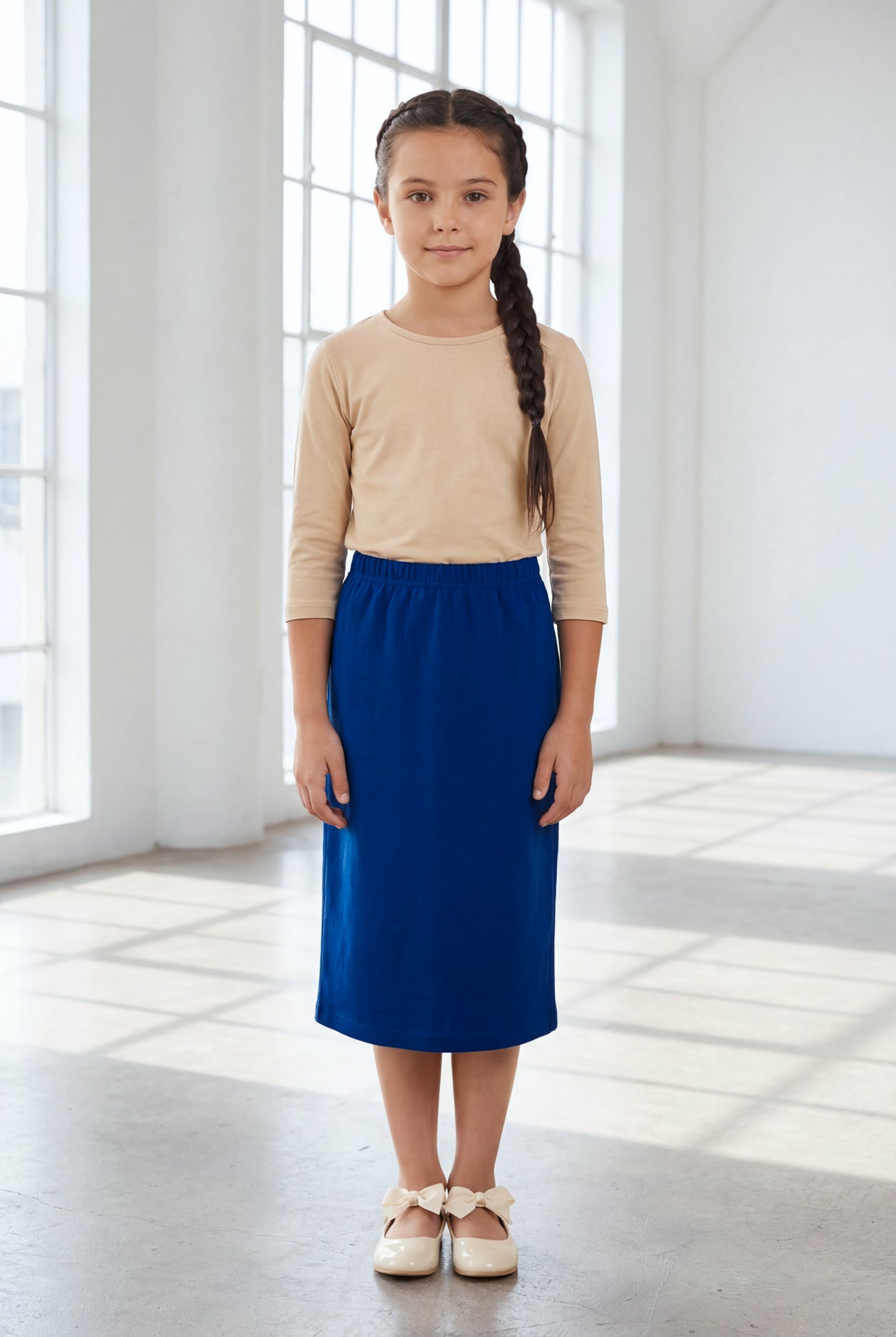 Model wearing the Nuggles® Girls' Classic Midi Skirt in Dark Royal Blue
