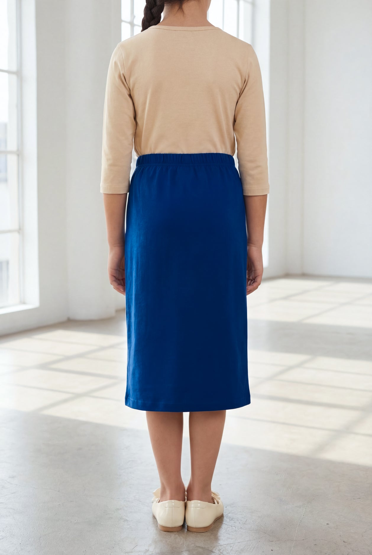 Model wearing the Nuggles® Girls' Classic Midi Skirt in Dark Royal Blue