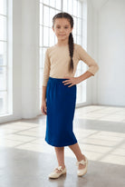 Model wearing the Nuggles® Girls' Classic Midi Skirt in Dark Royal Blue