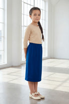 Model wearing the Nuggles® Girls' Classic Midi Skirt in Dark Royal Blue