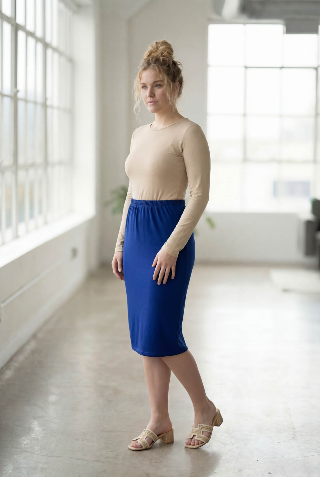 Women wearing a brick dark royal classic 27" midi length skirt with a beige shirt in a sunlight loft.