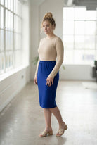 Women wearing a brick dark royal classic 27" midi length skirt with a beige shirt in a sunlight loft.