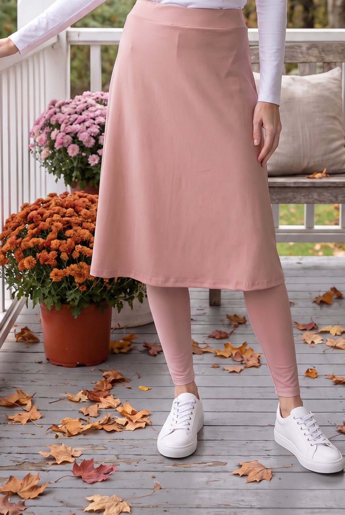 Nuggles® Tilly Sport Skirt in Dusty Pink, waist-down front view with one hand on the porch railing and matching leggings