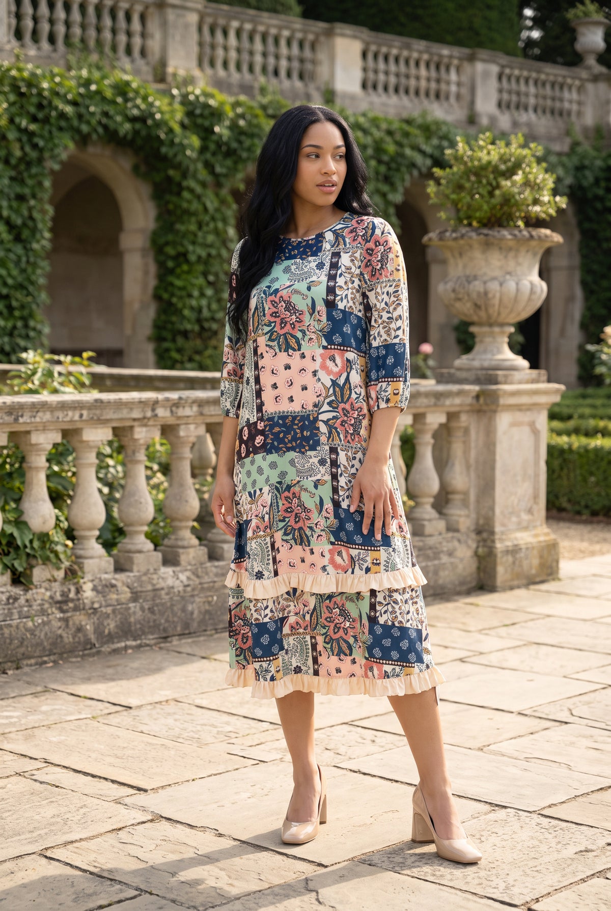 Nuggles® Patricia Dress in English Garden, full length on a stone terrace, tiered midi skirt and 3/4 sleeves