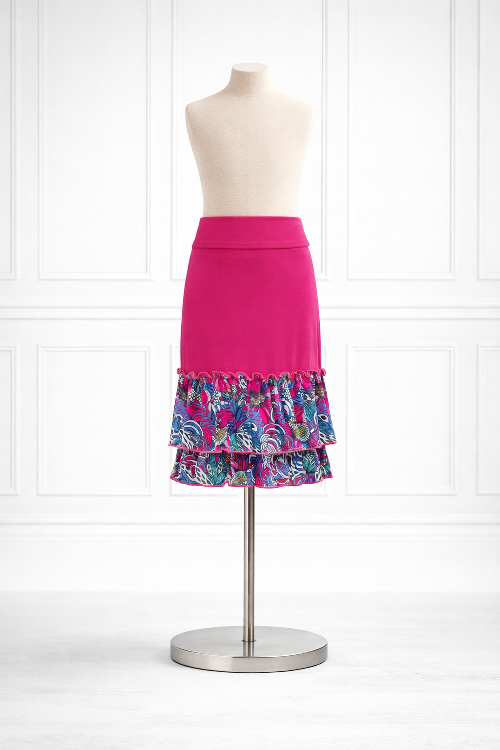 Mannequin wearing a pink skirt with a colorful ruffled bottom on a white background