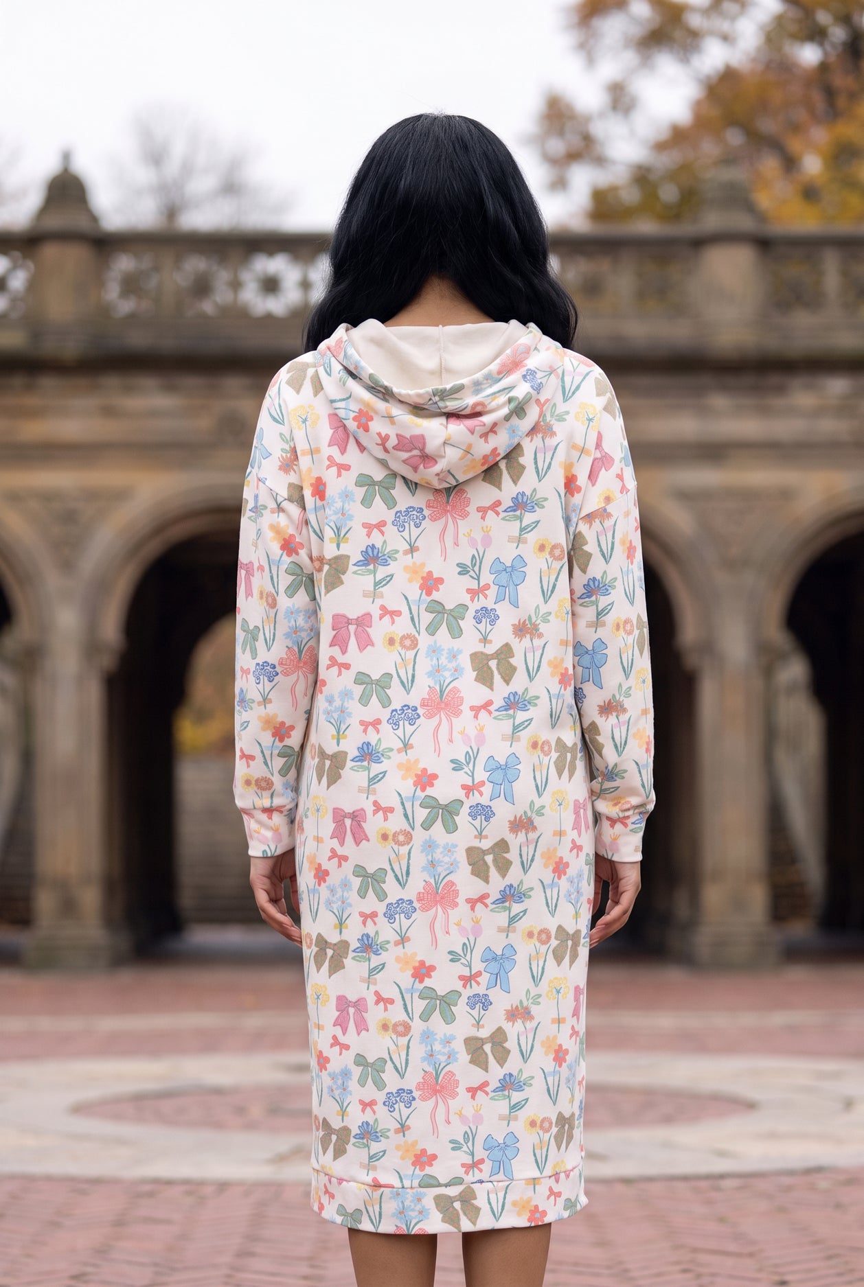Nuggles® Hoodie Dress in Garden Party, back view with the hood down over its cream lining