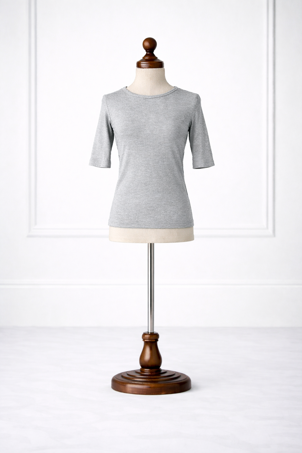 Gray t-shirt on a wooden mannequin against a white background