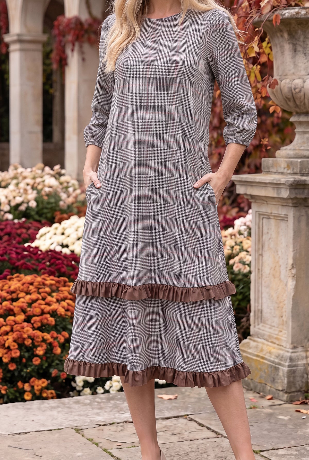 Nuggles® Patricia Dress in Glen Plaid, both hands in the side pockets above the brown ruffle trim