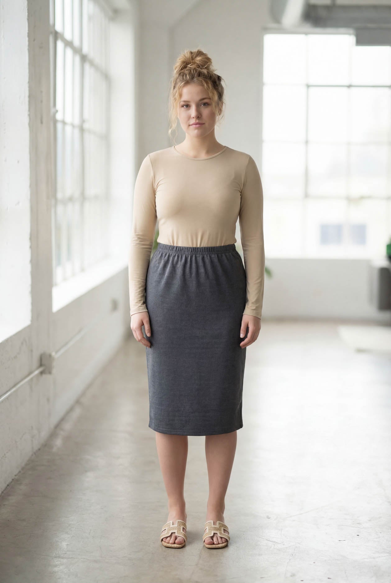 Women wearing a heather gray classic 27" midi length skirt with a beige shirt in a sunlight loft.