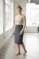 Women wearing a heather gray classic 27" midi length skirt with a beige shirt in a sunlight loft.