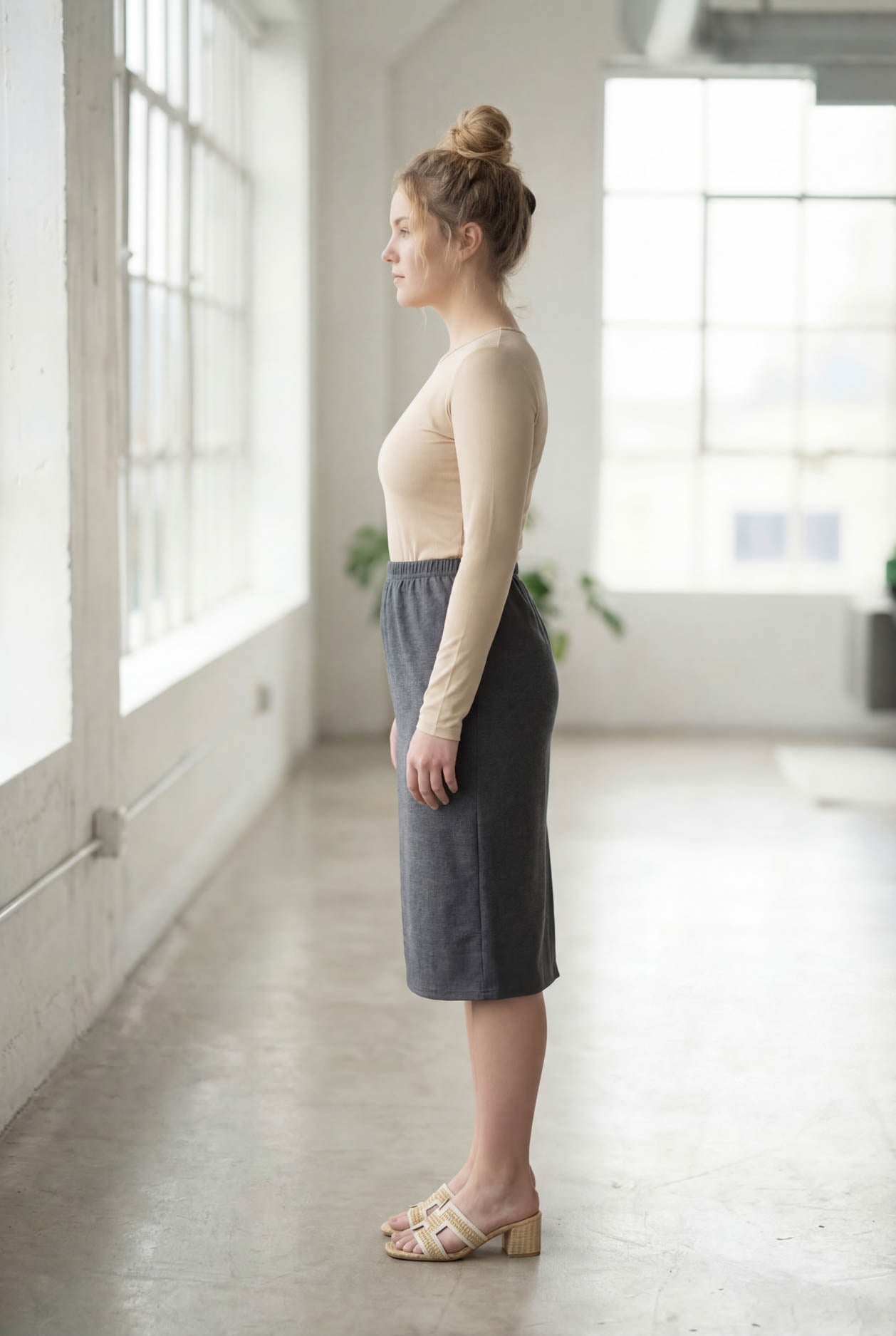 Women wearing a heather gray classic 27" midi length skirt with a beige shirt in a sunlight loft.