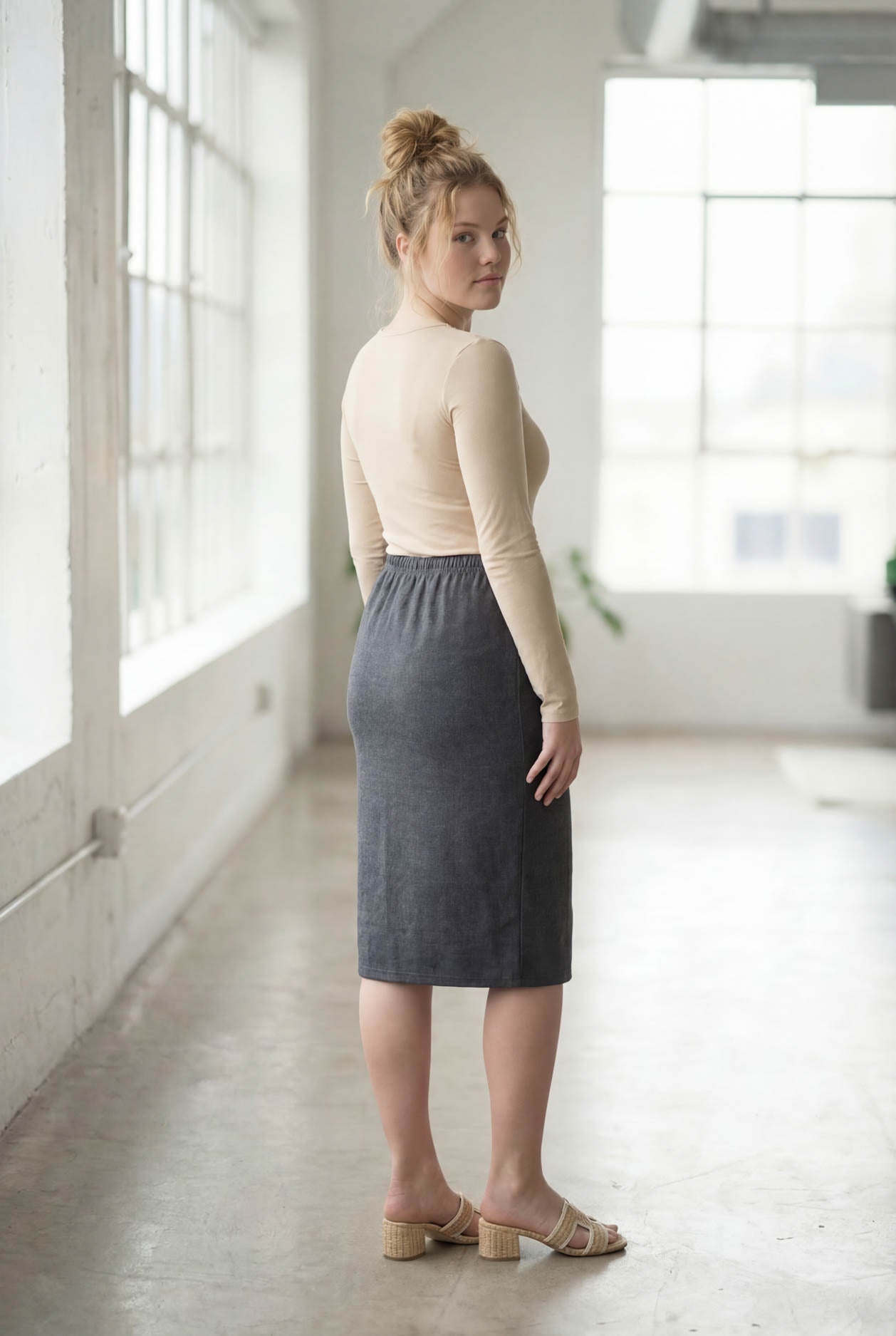 Women wearing a heather gray classic 27" midi length skirt with a beige shirt in a sunlight loft.