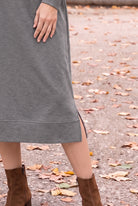 Nuggles® Oakley Hoodie Dress in Heather Gray, close-up of the banded hem and side slit and brown ankle boots on fallen leaves