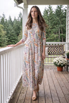 Nuggles® Cleo Maxi Dress in Hedgerow, full length on a porch with one hand on the rail, glancing to the side