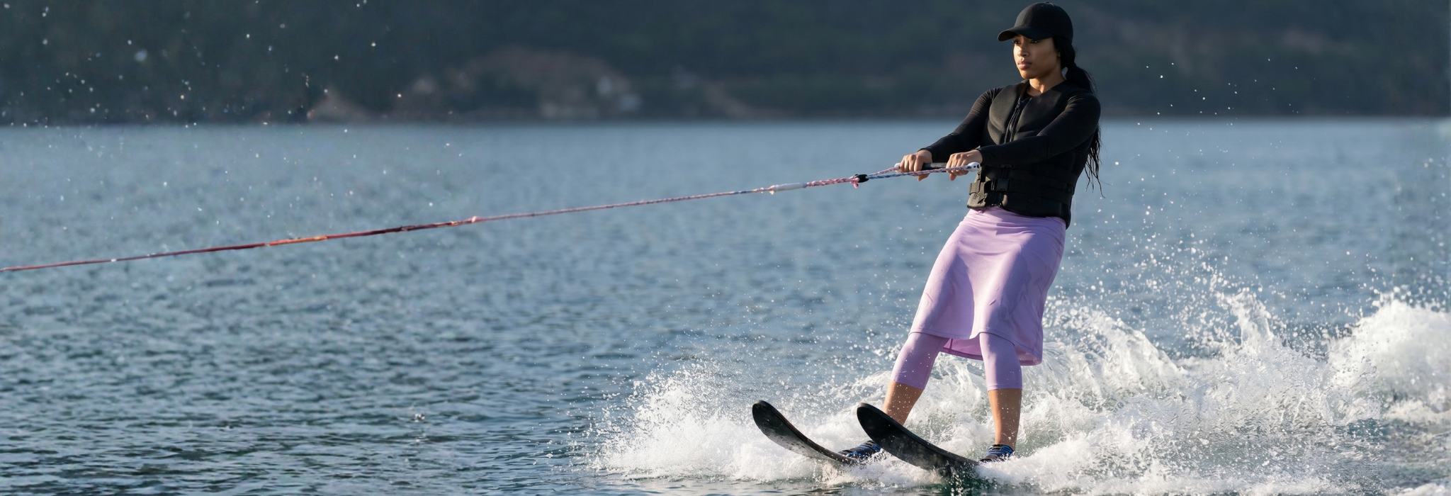 Person water skiing on a lake with mountains in the background