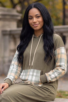 Model wearing Nuggles®  Hoodie Dress in Olive Plaid
