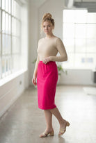 Women wearing a brick hot pink classic 27" midi length skirt with a beige shirt in a sunlight loft.
