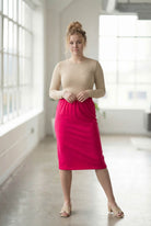 Women wearing a brick hot pink classic 27" midi length skirt with a beige shirt in a sunlight loft.